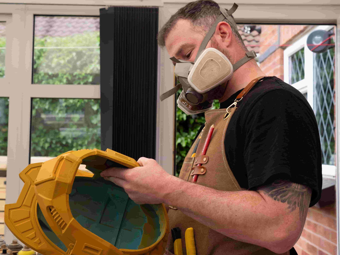Prop maker assembling helmet build while preparing inventory for comic con at The Cosforge workshop